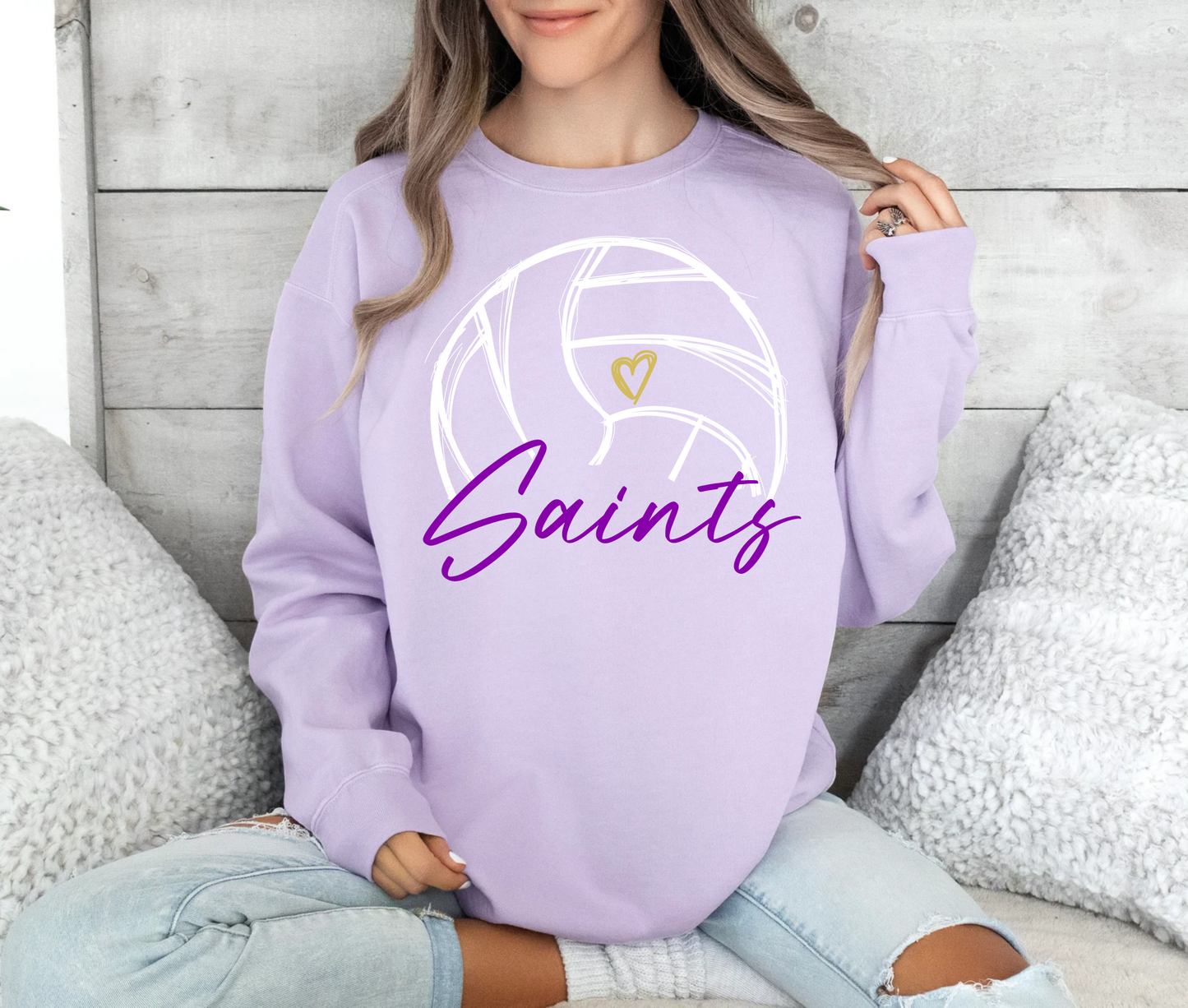 Person wearing a lavender sweatshirt with 'Saints' and a volleyball design.