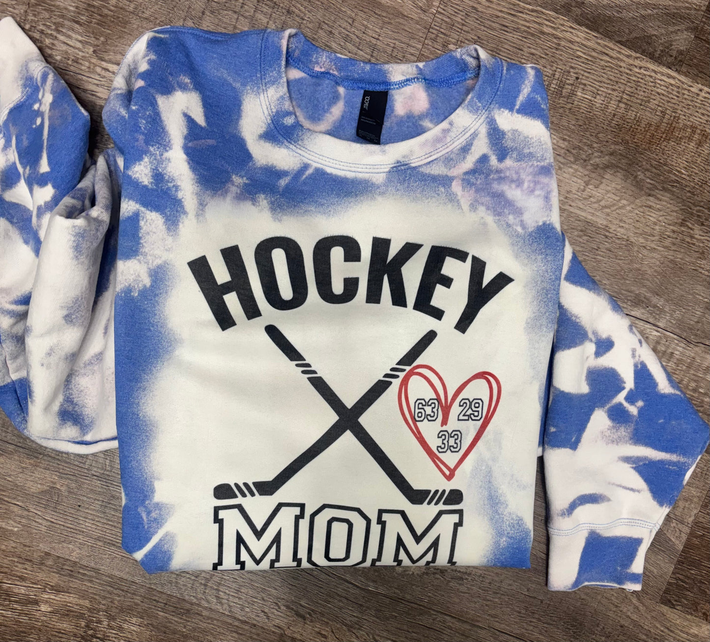 Personalized bleached hockey mom sweatshirt from Liv's Boutique, featuring a stylish, casual design with custom text.