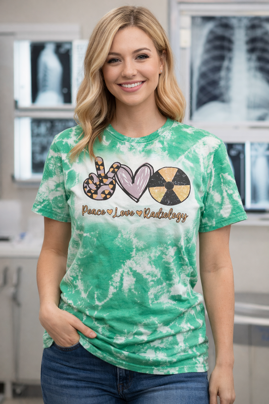 Woman wearing a green tie-dye t-shirt with 'Peace Love Radiology' design in a medical setting.